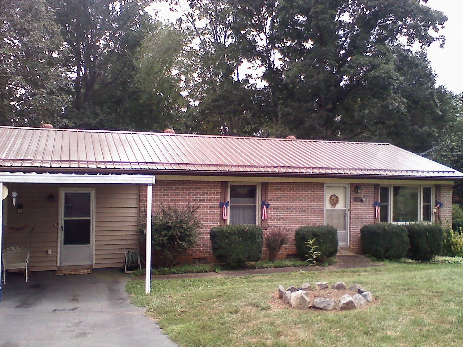 Bronze metal roof and carport on a brick ranch home — Roof Repair work by our crew in Freeland